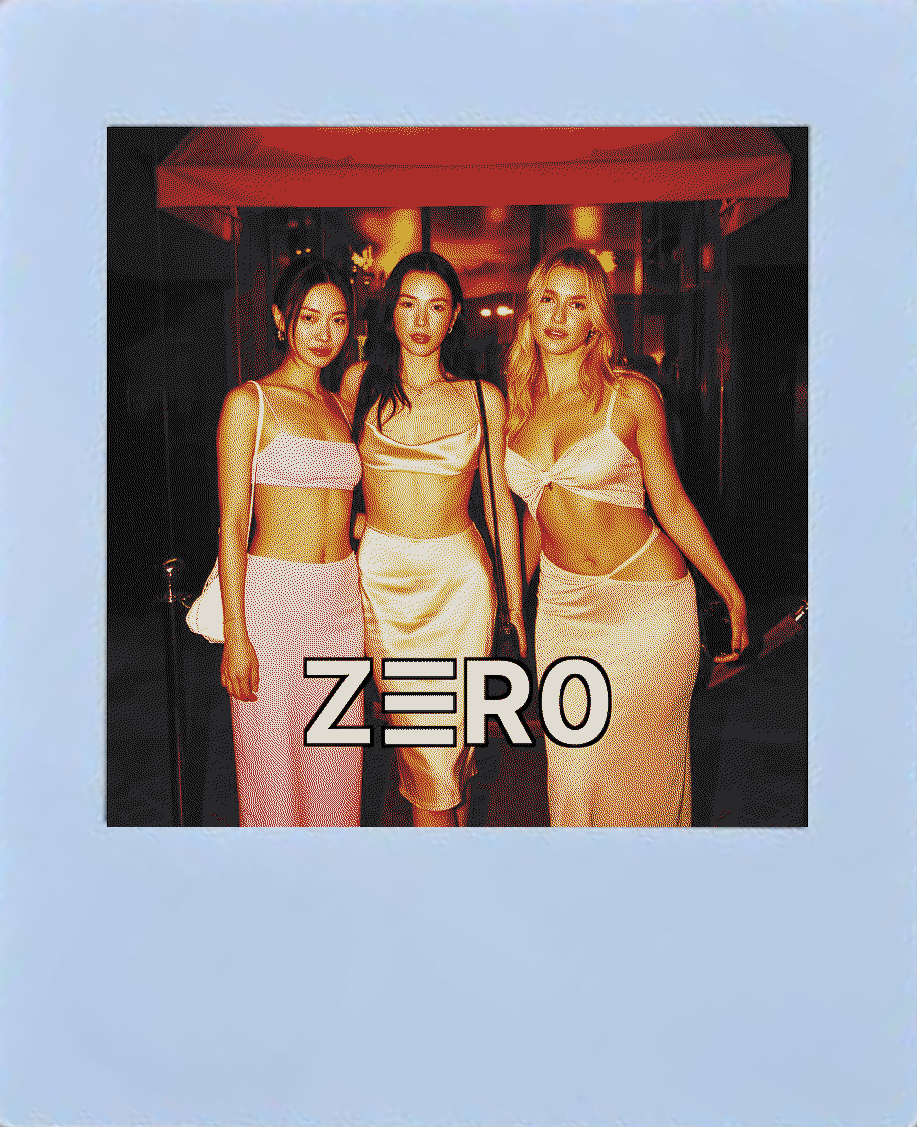Card with three women arm-linked outside a night venue, direct flash, dark surround.