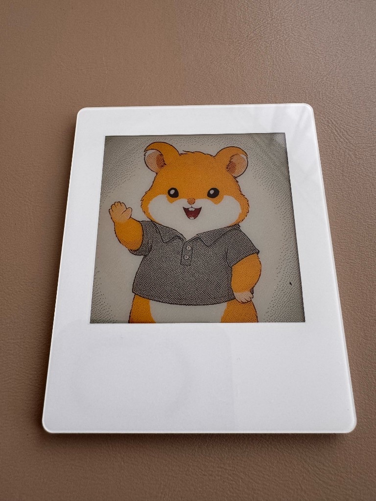The Z3R0 card lying tilted on a light wood desk, screen dark — an unretouched phone photograph.